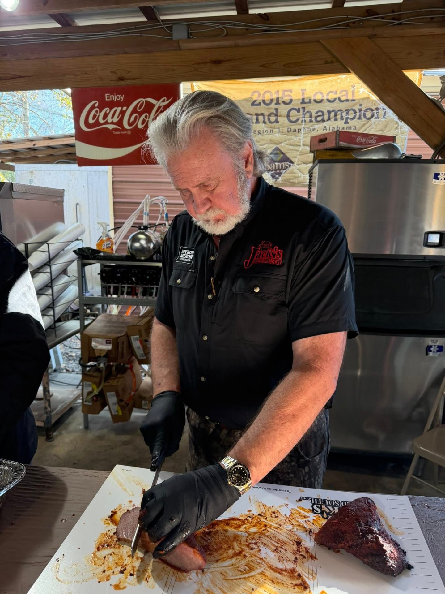 Pitmaster tending offset smoker with billowing smoke